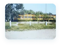 Одноповерхова виробнича будівля з жовтим фасадом за відкритим майданчиком
